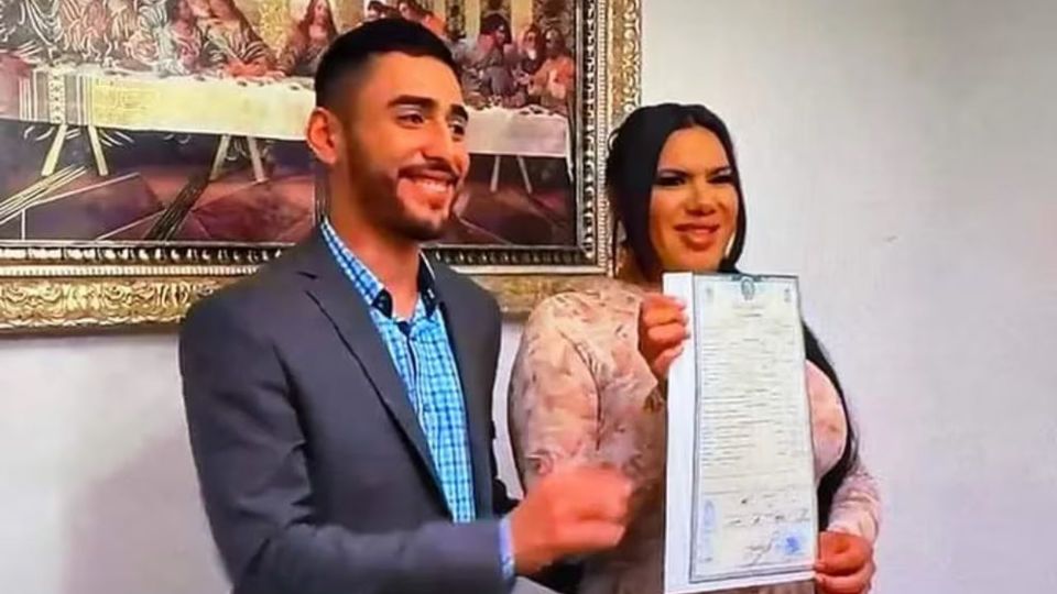 El flamante matrimonio con el acta que los transforma en esposos.